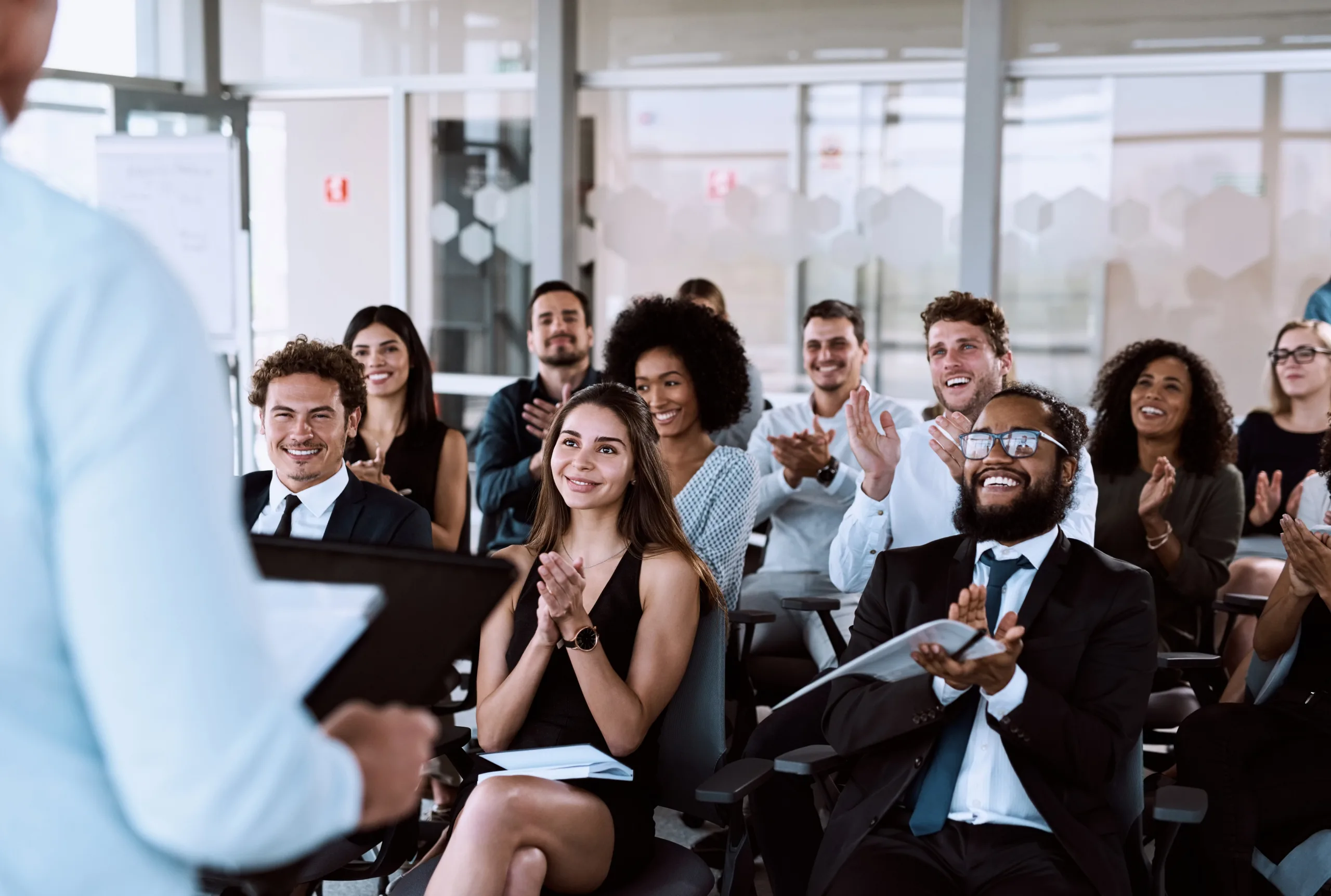 An audience of business people applauding a speaker