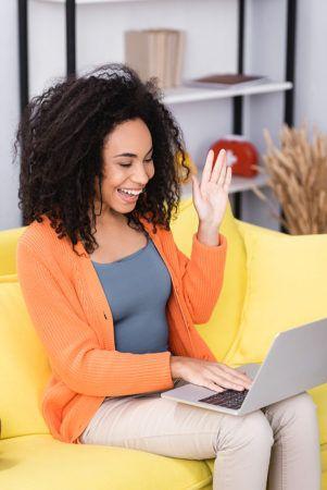 Happy woman Waving Hand During Video Call At Home