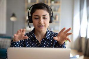 Anxiety in the office; a woman is looking nervously at her laptop screen