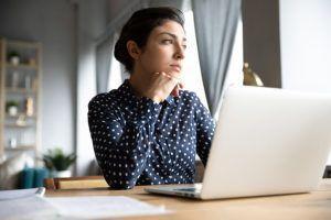 Thoughtful Female Distracted From Computer Work