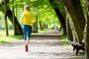 Woman running along path in a park